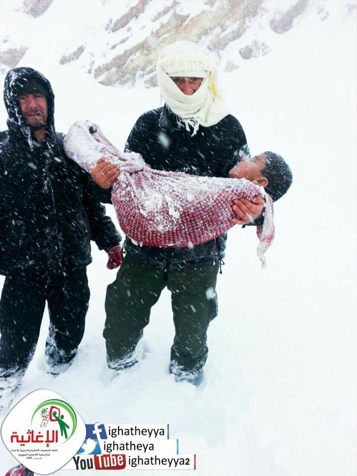 بالصور: أب يحمل جثة طفله الذي مات من البرد